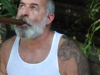 Viejo barbudo fumando puro