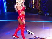 WWE - Carmella in red outfit standing over Sasha Banks