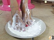 Barefoot brunette covers her feet in sweet cream
